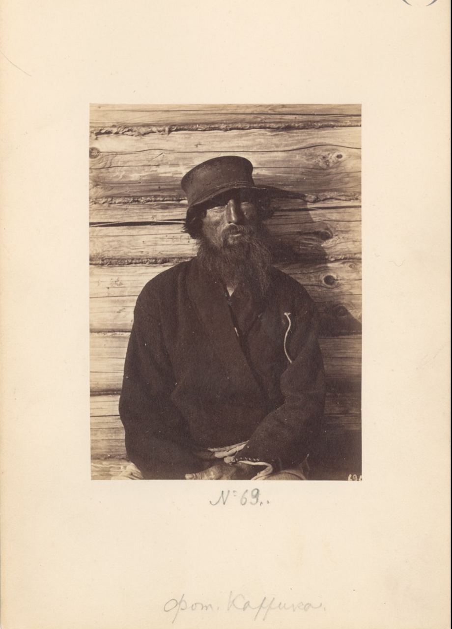 Крестьянин на фоне избы. 1870-е